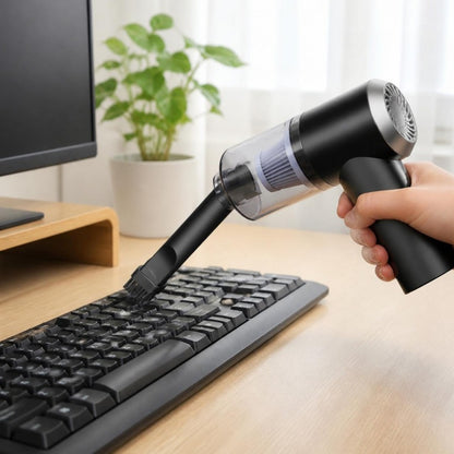 Aspirador portatil limpando o teclado em casa